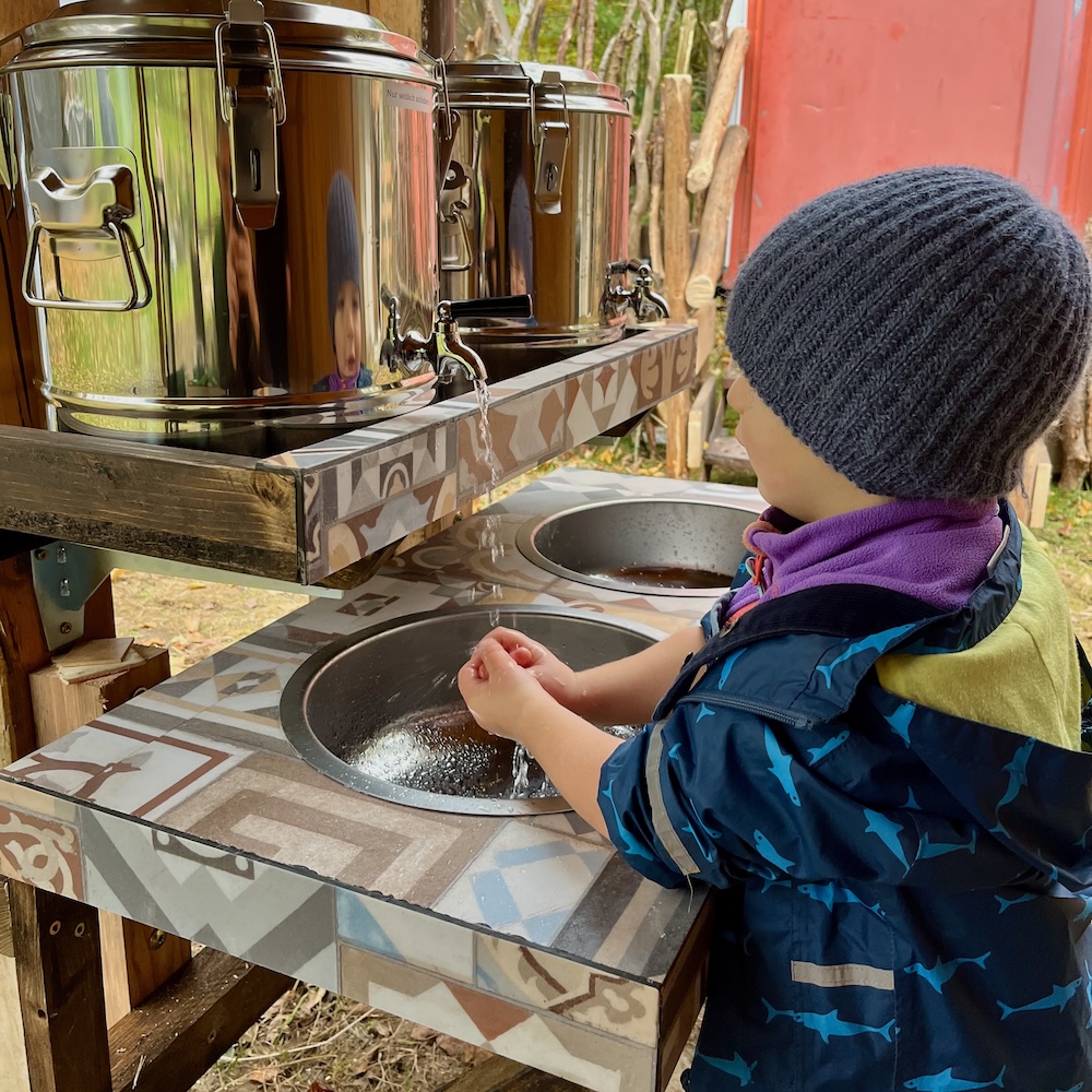 Waschplatz mit befestigten Wasserkanistern für die Kinder